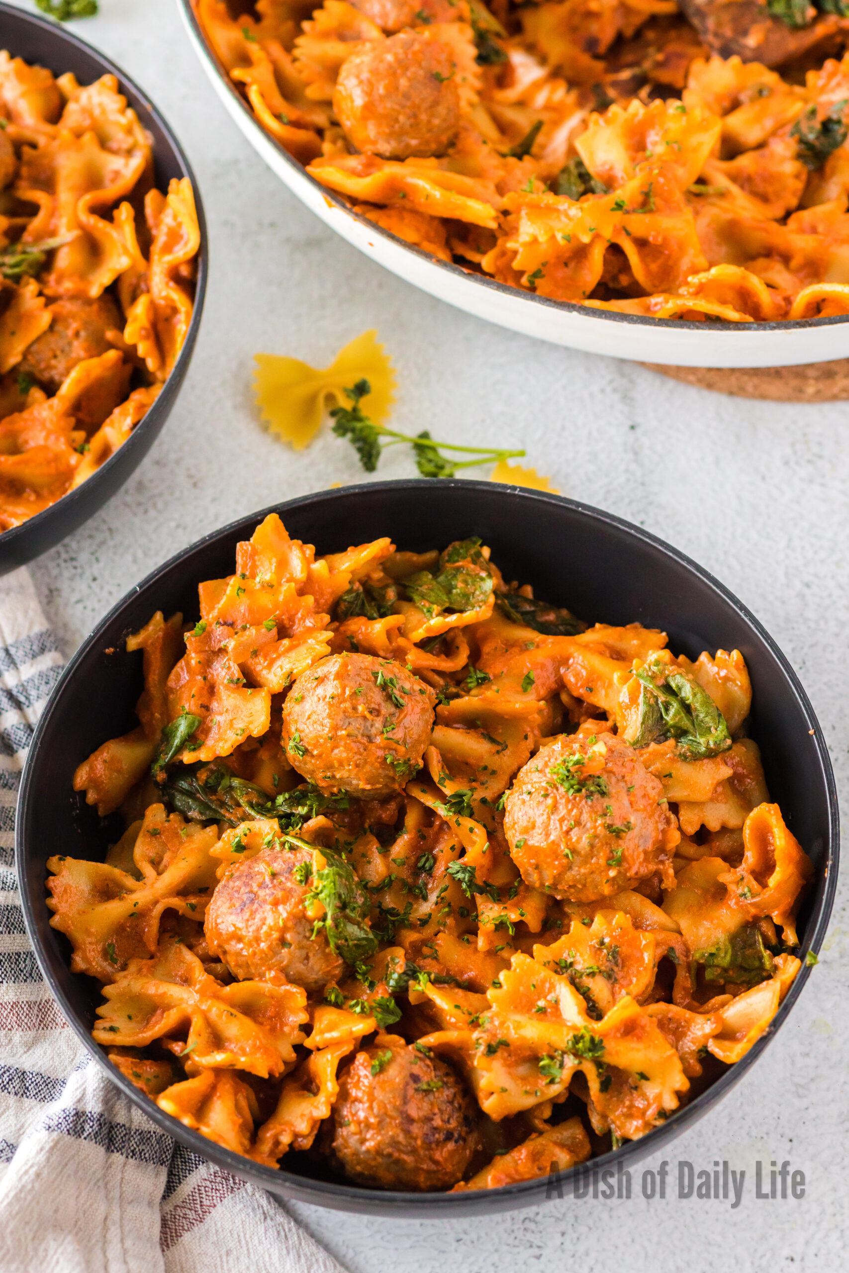 bowl full of pasta and meatballs, ready to eat