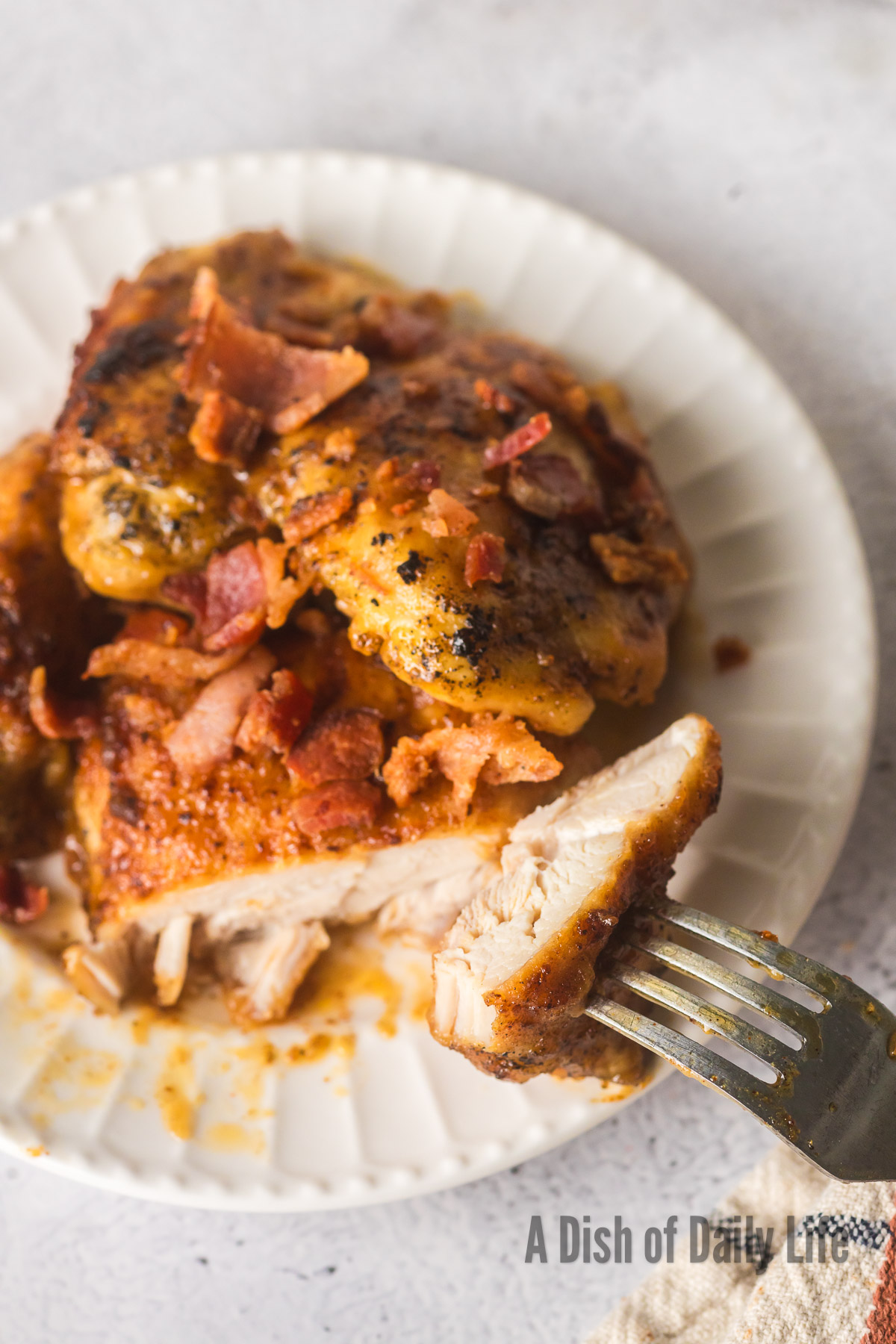 chicken thigh on plate cut with a fork in the sliced piece