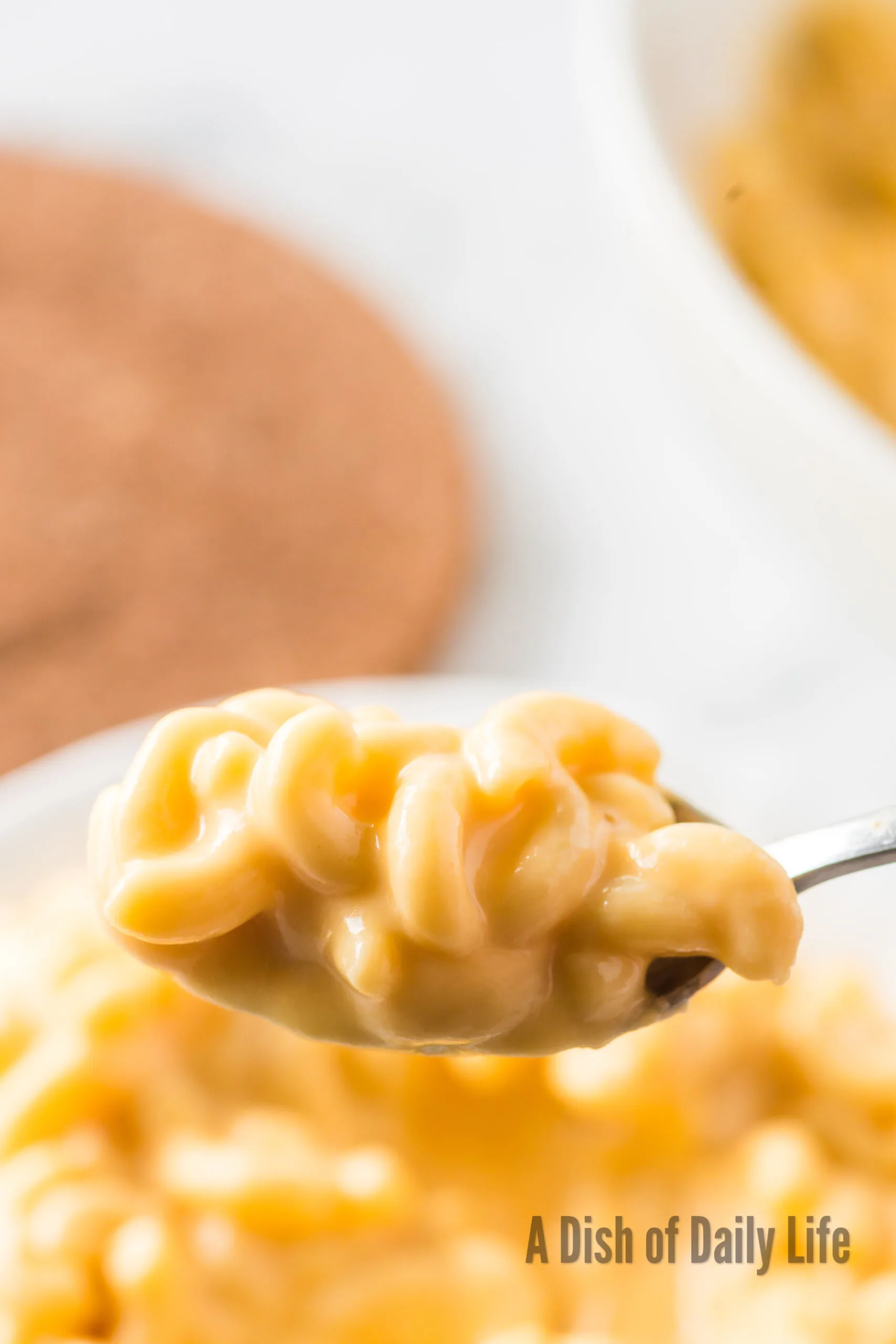 a small bowl of macaroni and cheese with a spoon scooping a portion out.