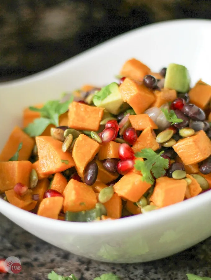 This Sweet Potato Salad with a Southwest Vinaigrette is one of our favorites for summer. The combination of sweet potatoes, black beans, crunchy pumpkin seeds, and juicy pomegranate seeds makes a wonderful side dish recipe for potlucks or even dinner. It would make a great vegetarian lunch too!