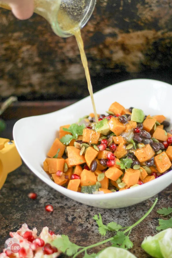 This Sweet Potato Salad with a Southwest Vinaigrette is one of our favorites for summer. The combination of sweet potatoes, black beans, crunchy pumpkin seeds, and juicy pomegranate seeds makes a wonderful side dish recipe for potlucks or even dinner. It would make a great vegetarian lunch too!