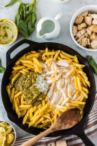 pesto and half and half added to cooked pasta in skillet.