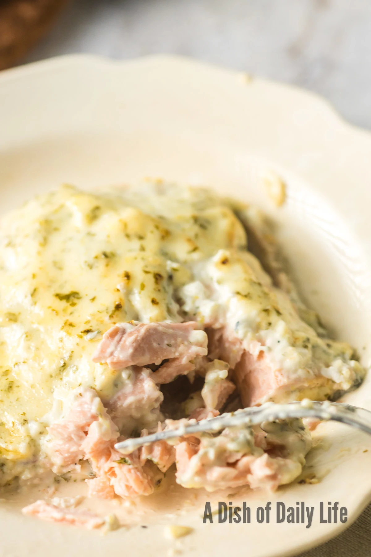 A fork pulling salmon apart to show how flaky it is.