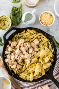Chicken and artichoke hearts added to pesto pasta