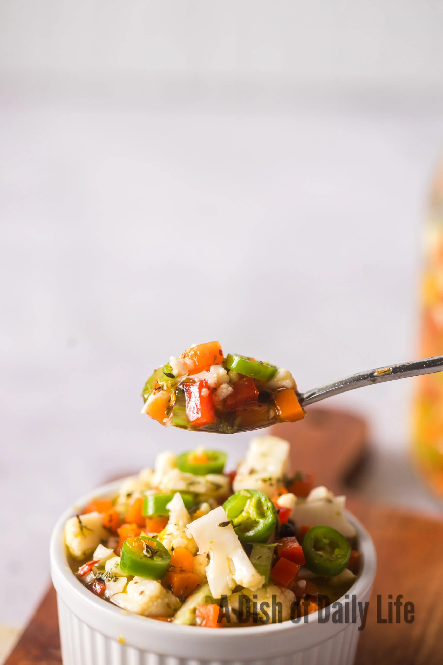 spoon scooping vegetables out of a bowl.