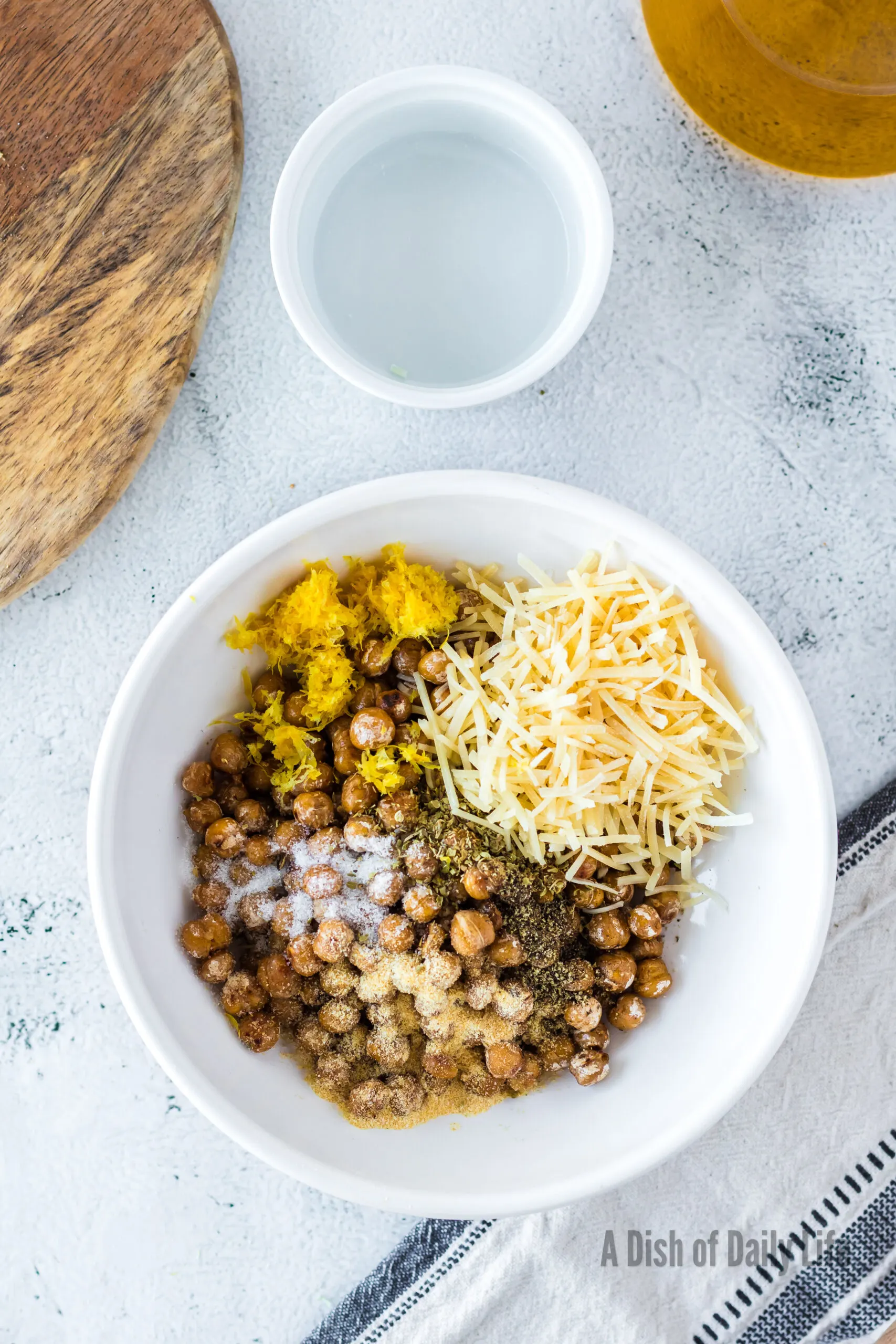 crispy chickpeas in a bowl with cheese, garlic powder, lemon, oregano, salt and pepper.