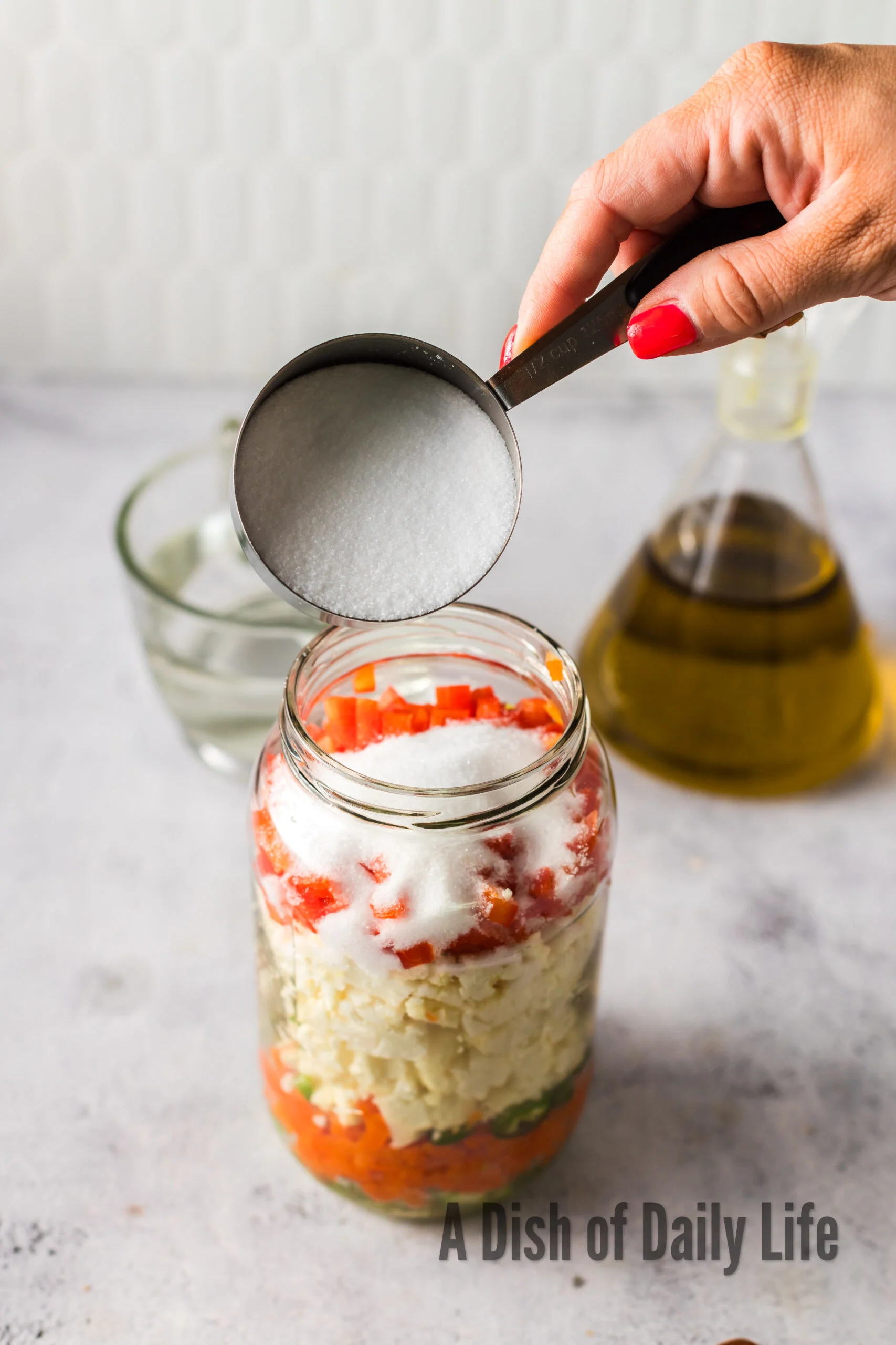 Salt added to vegetables in jar.