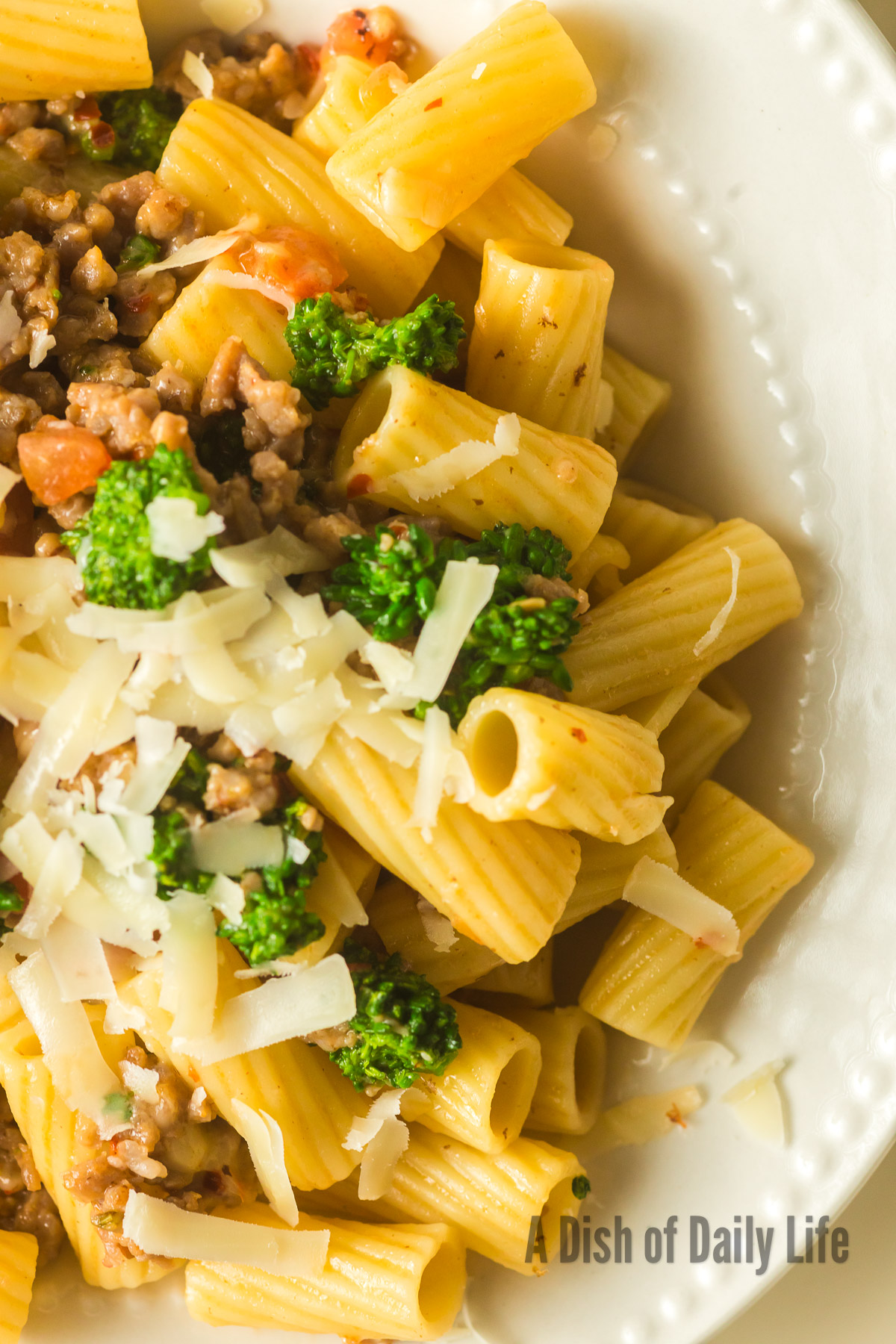 zoomed in image of sausage pasta in bowl to show yummy flavors.