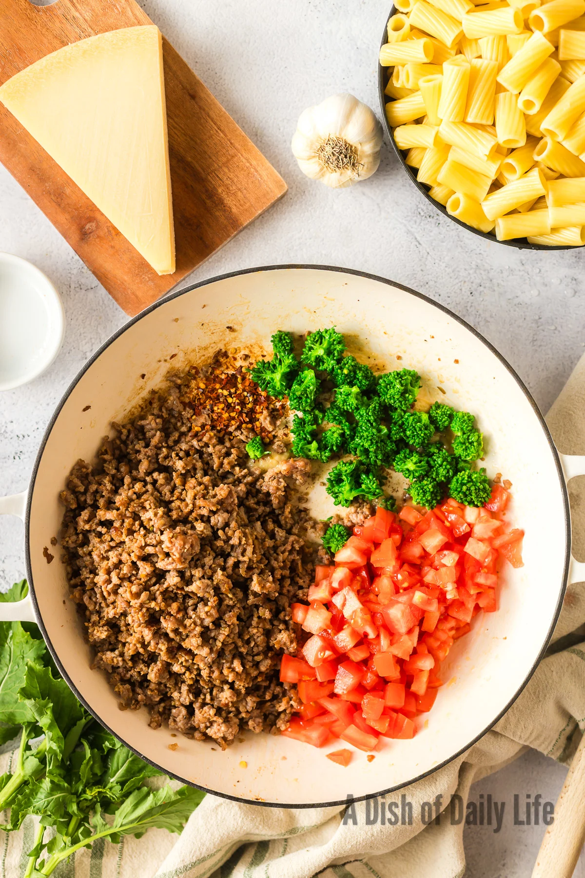 Chili f;akes, sausage, broccoli rabe and tomatoes added to garlic mixture.