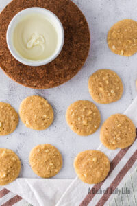 freshly baked cookies with a bowl of melted white chocolate.