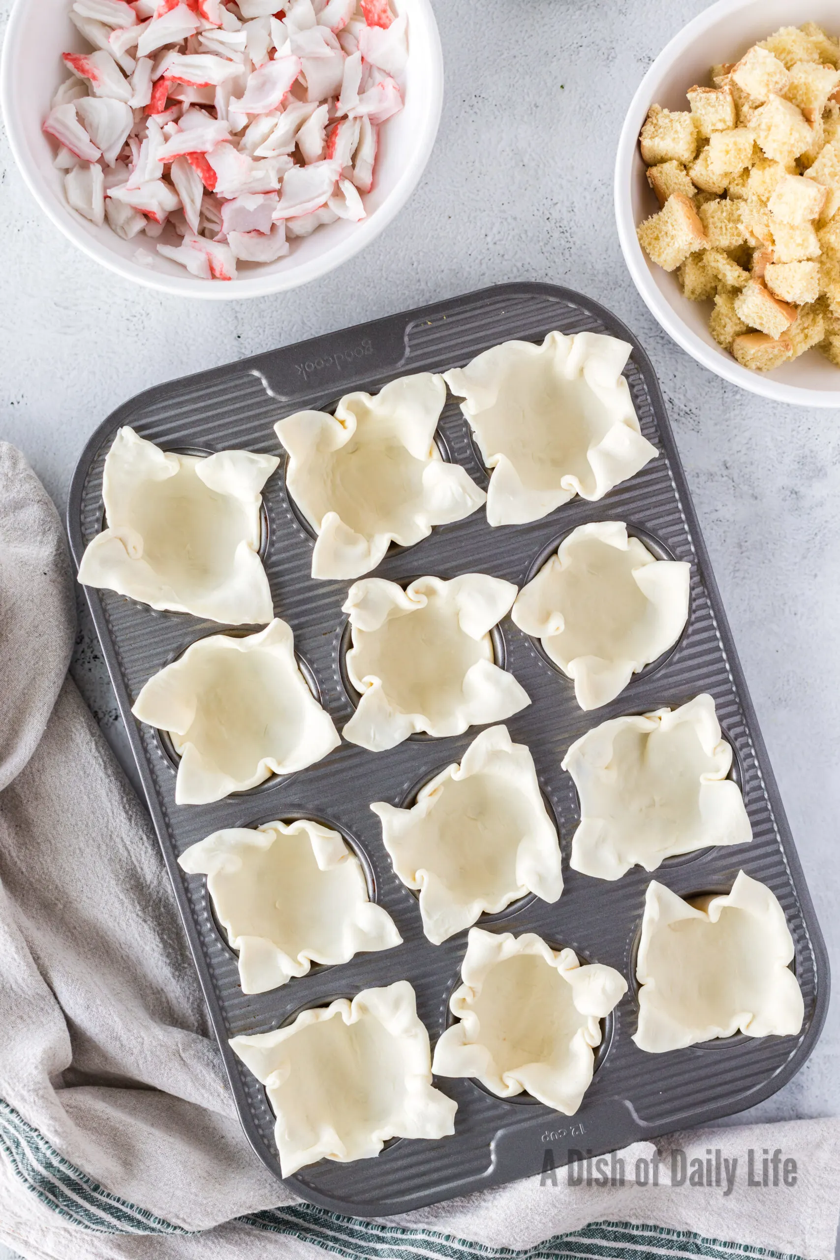 puff pastry squares placed in a muffin tin holder