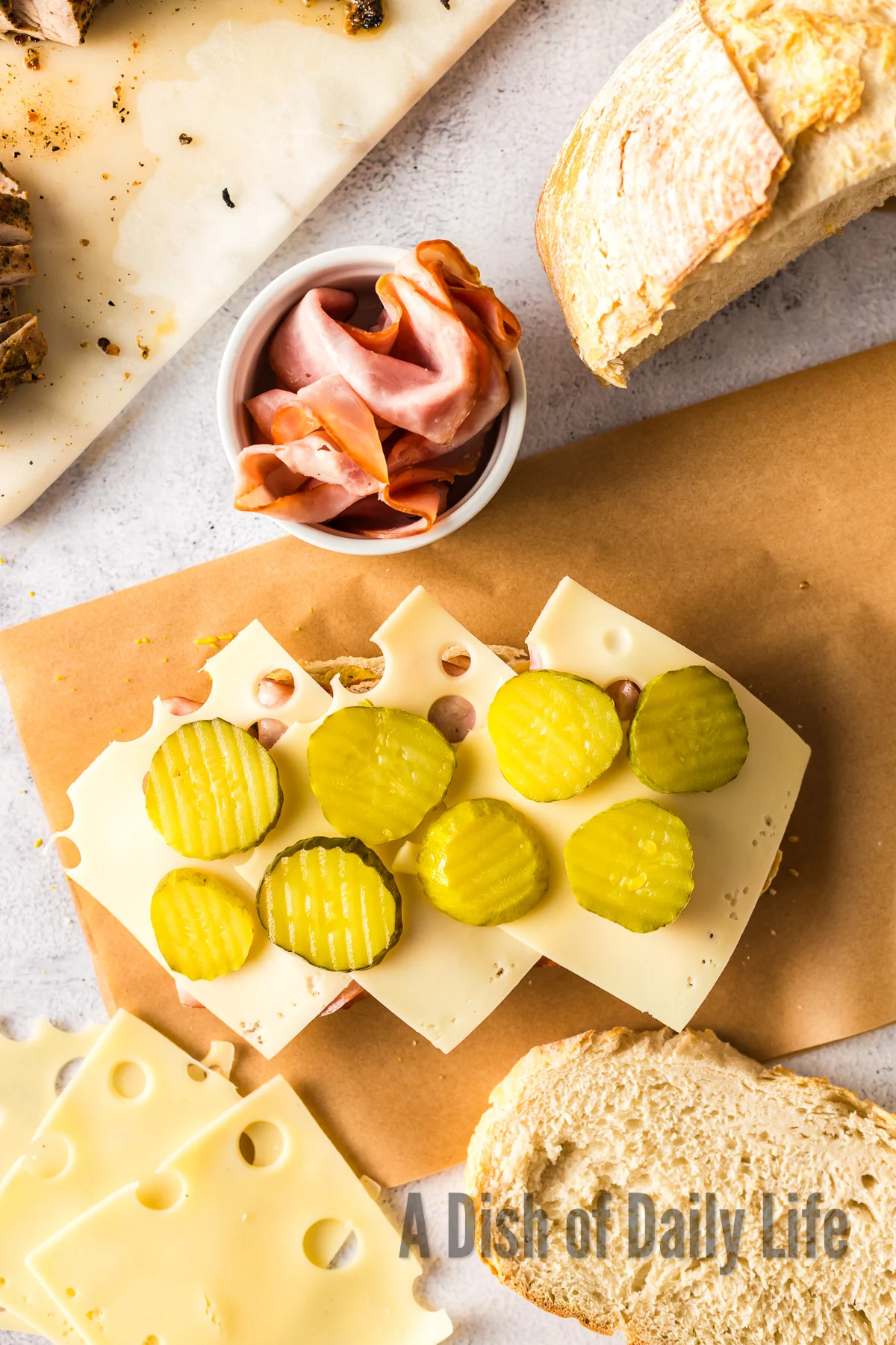 Pickled placed on top of swiss cheese on sandwich.