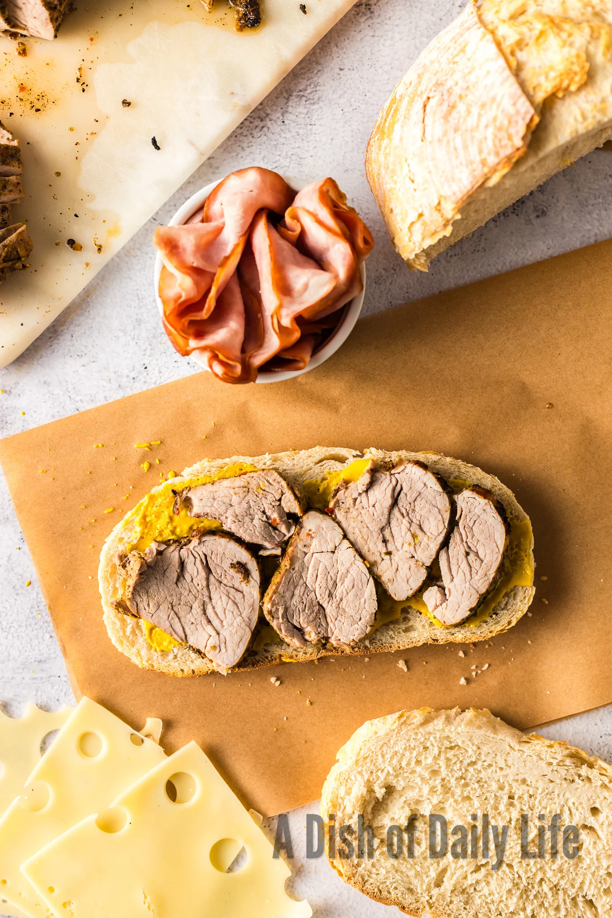 sliced cuban pork loin on top of mustard on bread.