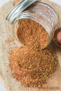 jar full of seasoning, tipped on its side with seasoning falling out. Photo taken from the top looking down