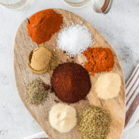 All fajita seasoning spiced laid out on a wooden board, ready to mix together to make fajita seasoning