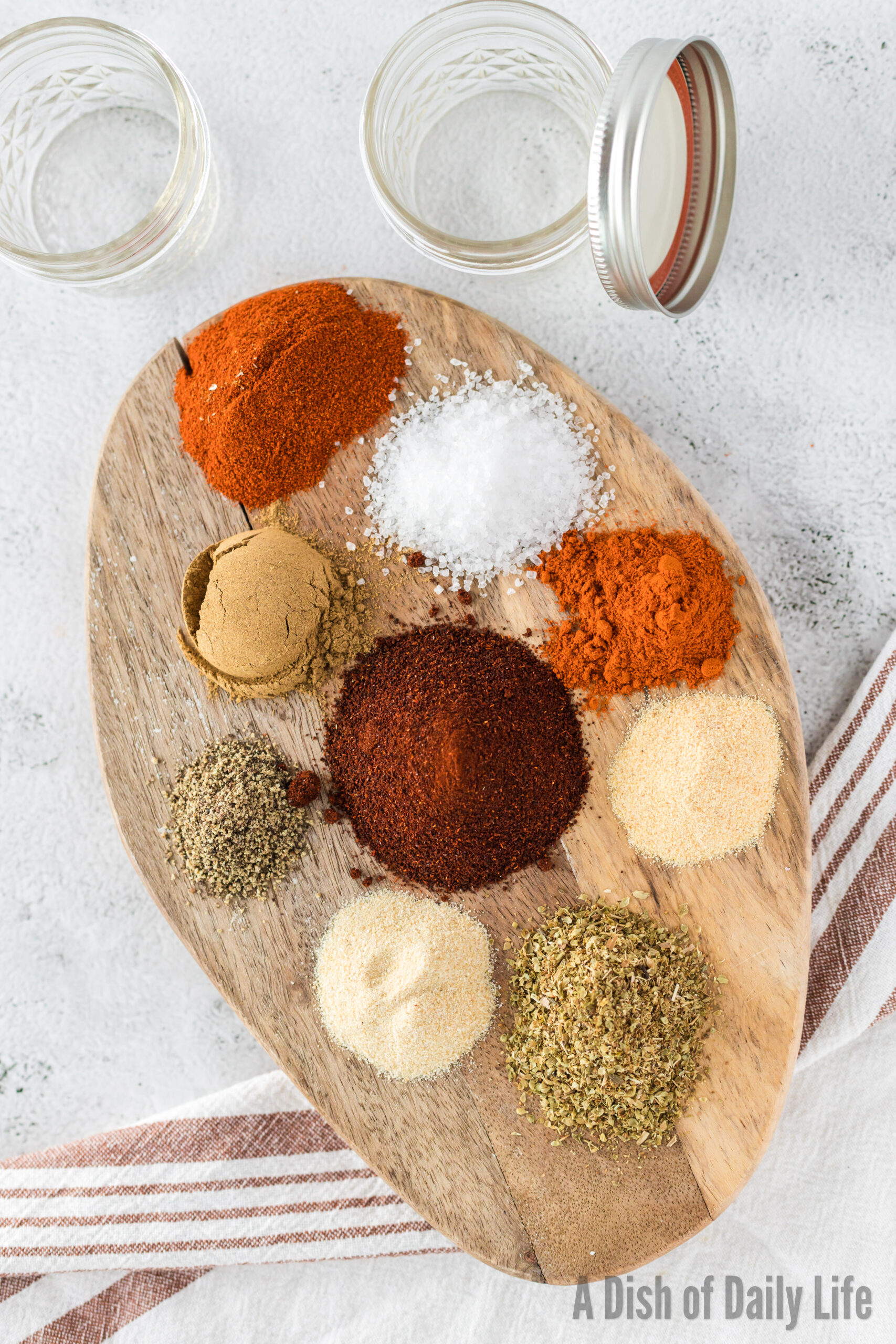 All fajita seasoning spiced laid out on a wooden board, ready to mix together to make fajita seasoning