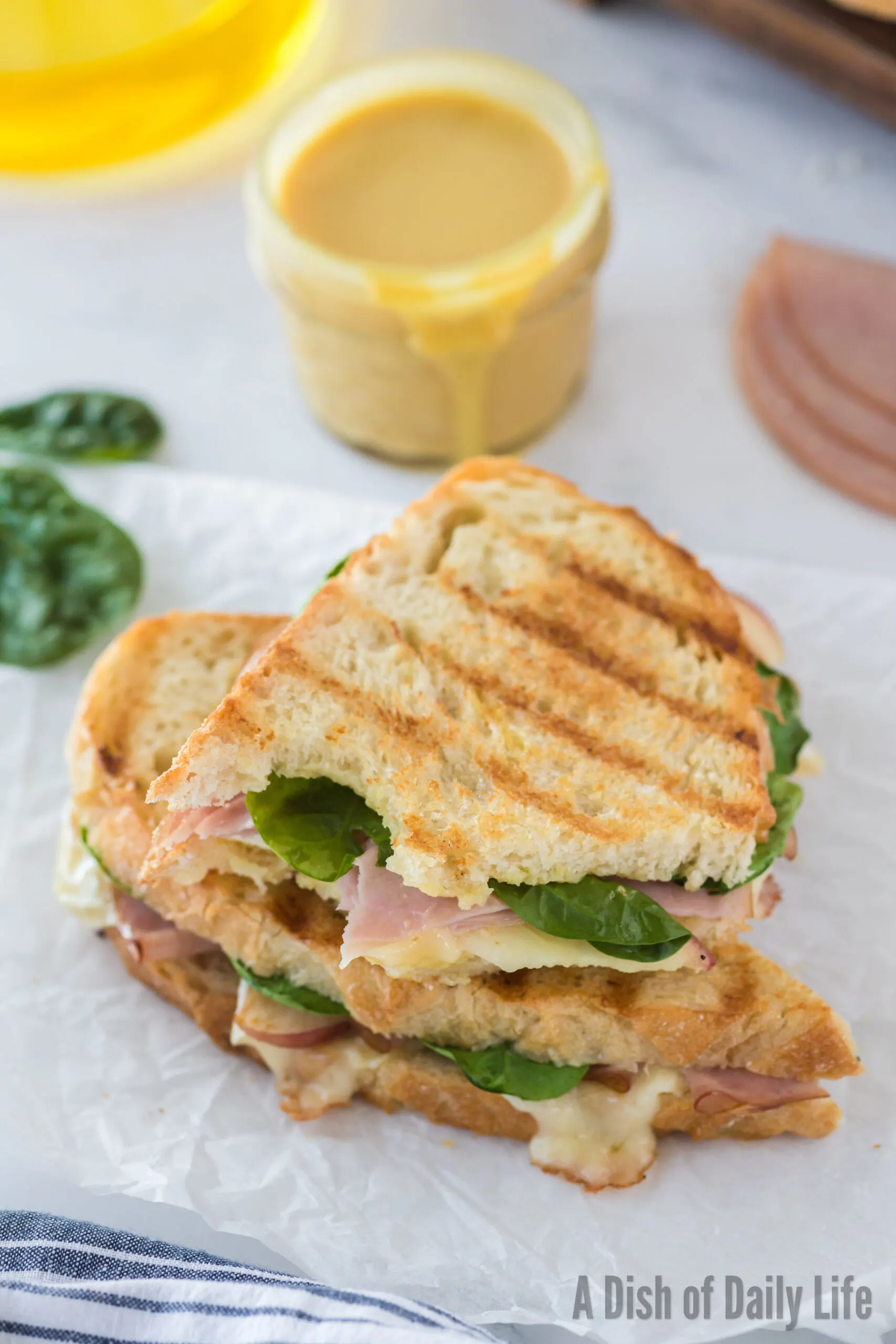 a brie panini sandwich stacked on top of each other, with a bite removed from the top half