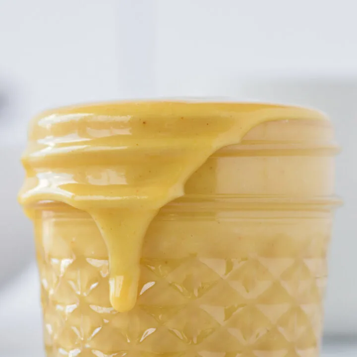 side view of honey mustard in jar with a little dripping down the side