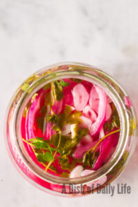 top view looking down at onions in a jar, ready to eat.