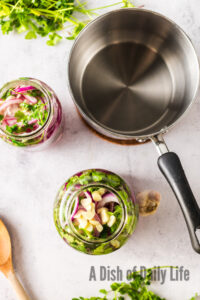 zoomed out image of prepared and filled jars with vinegar.