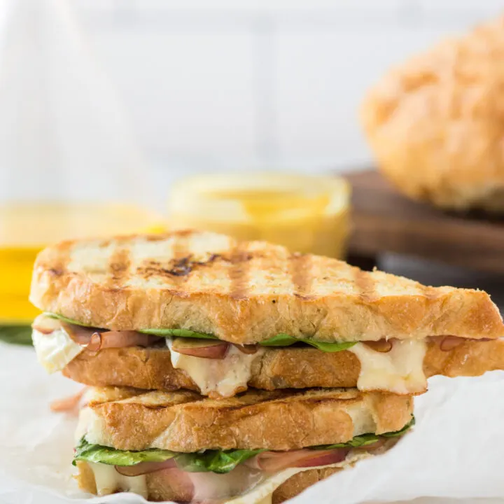 grilled ham and brie panini on counter stacked on top of each other