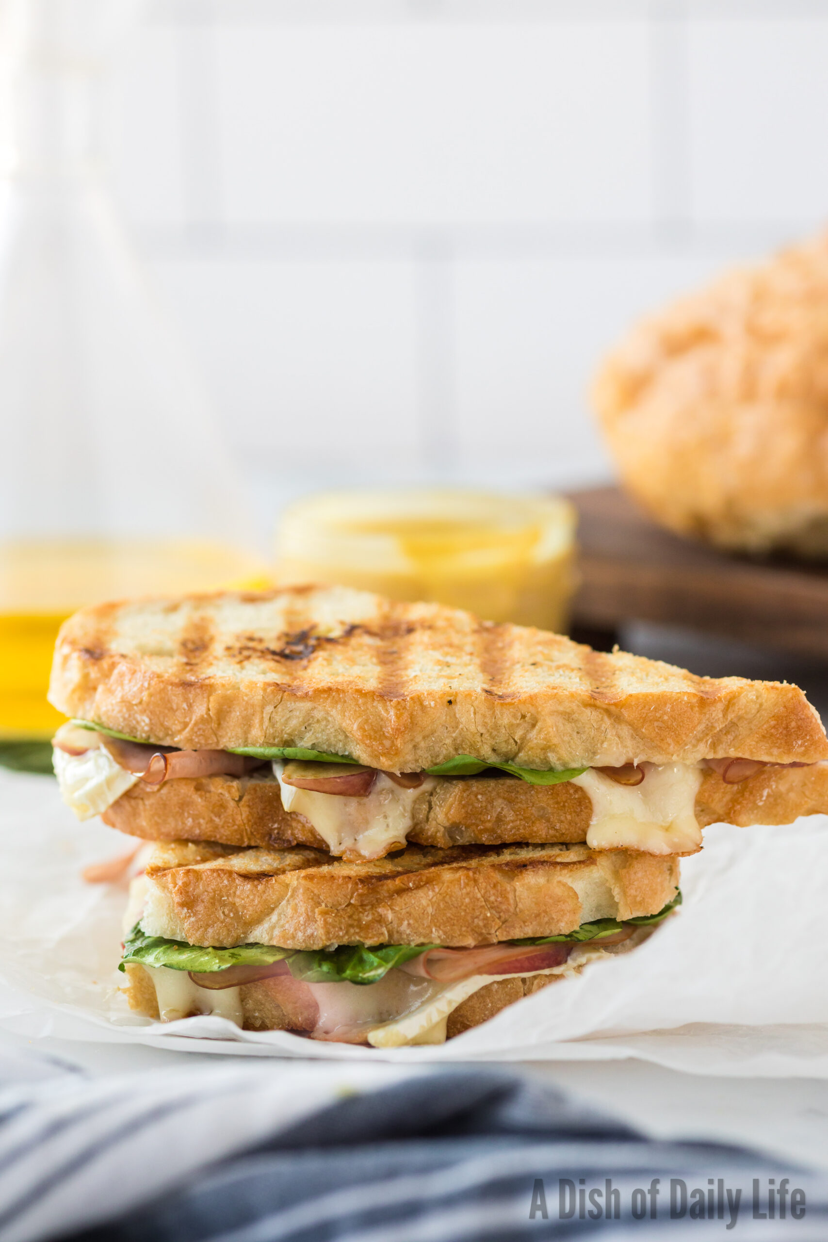 grilled ham and brie panini on counter stacked on top of each other