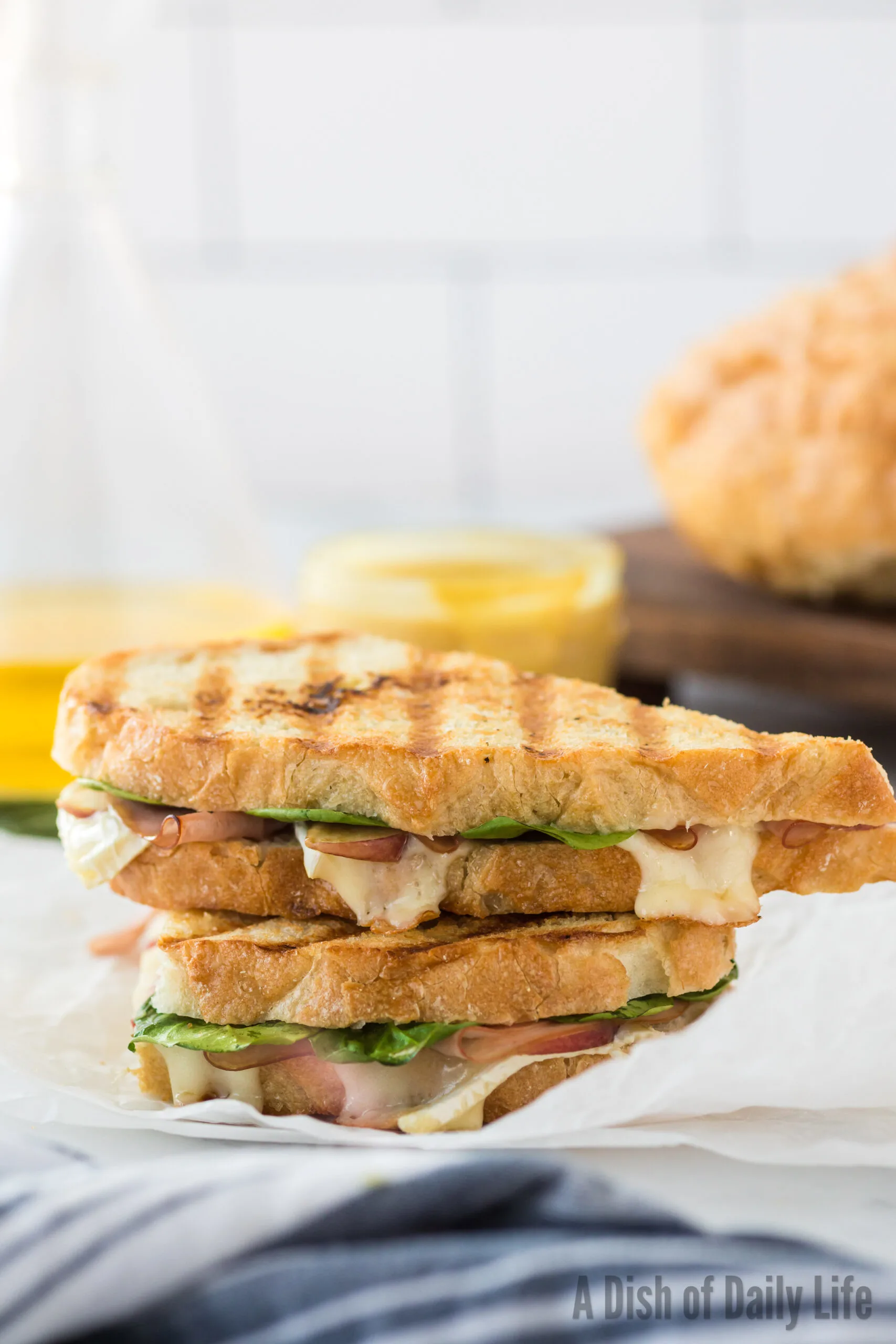 grilled ham and brie panini on counter stacked on top of each other