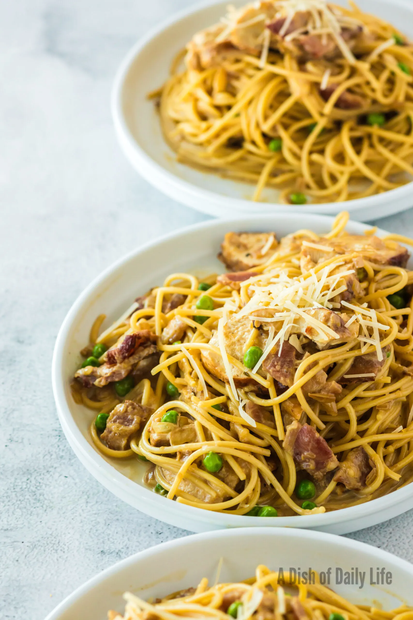 side view of 3 bowls of chicken carbonara in bowls ready to eat