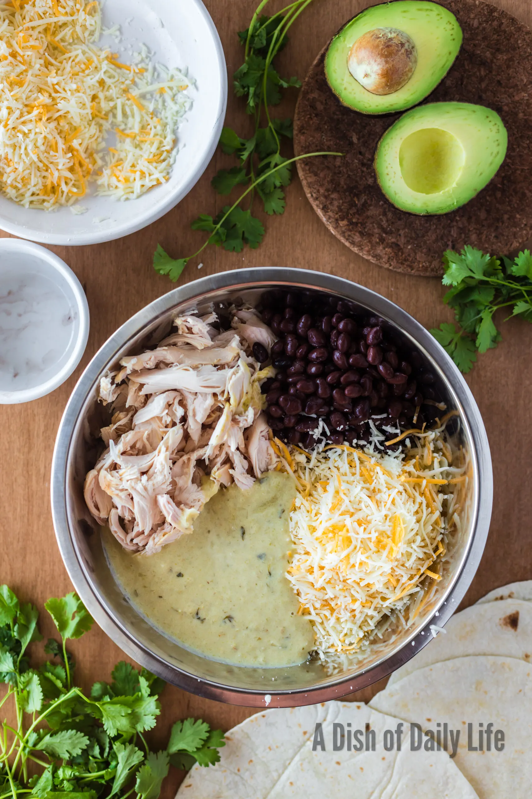 chicken, cheese, black beans and green chile yogurt sauce in a bowl, unmixed.