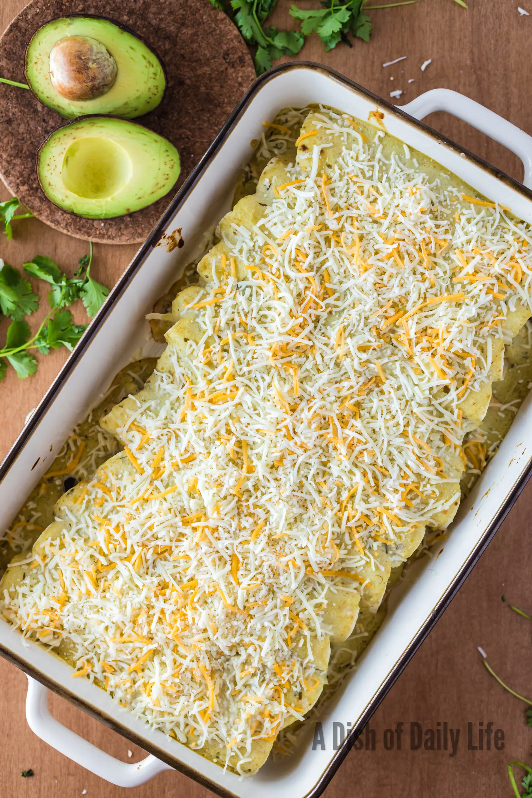 Shredded cheese sprinkled on top of enchiladas