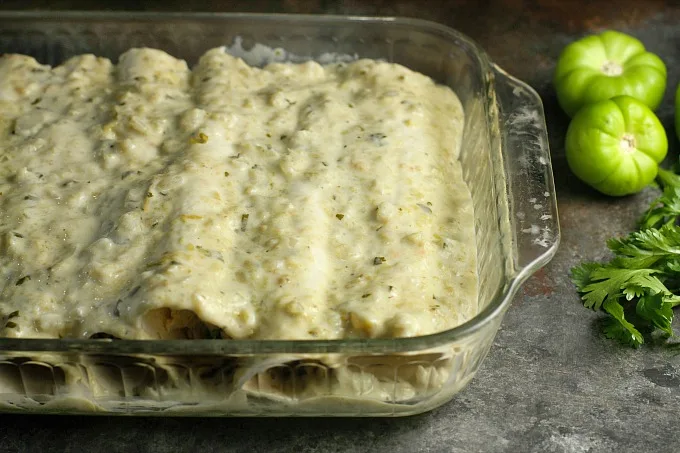 rolled enchiladas with sauce over the top