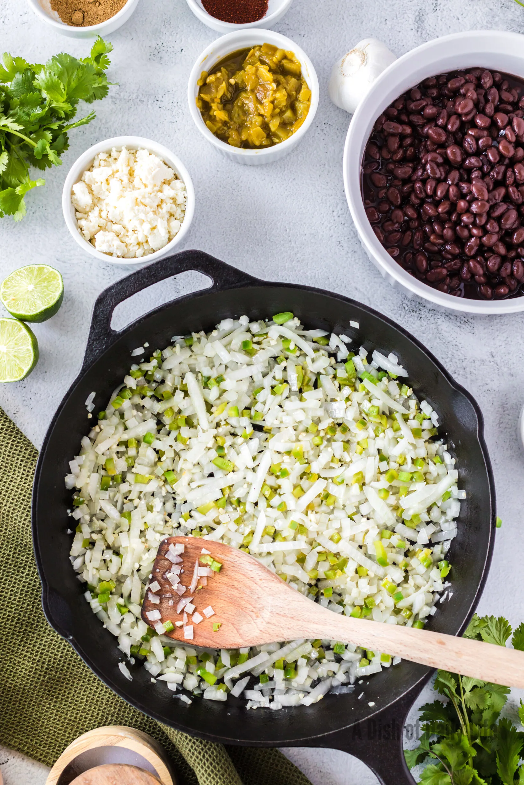 onions, garlic and jalapenos in a skillet being sautéed.