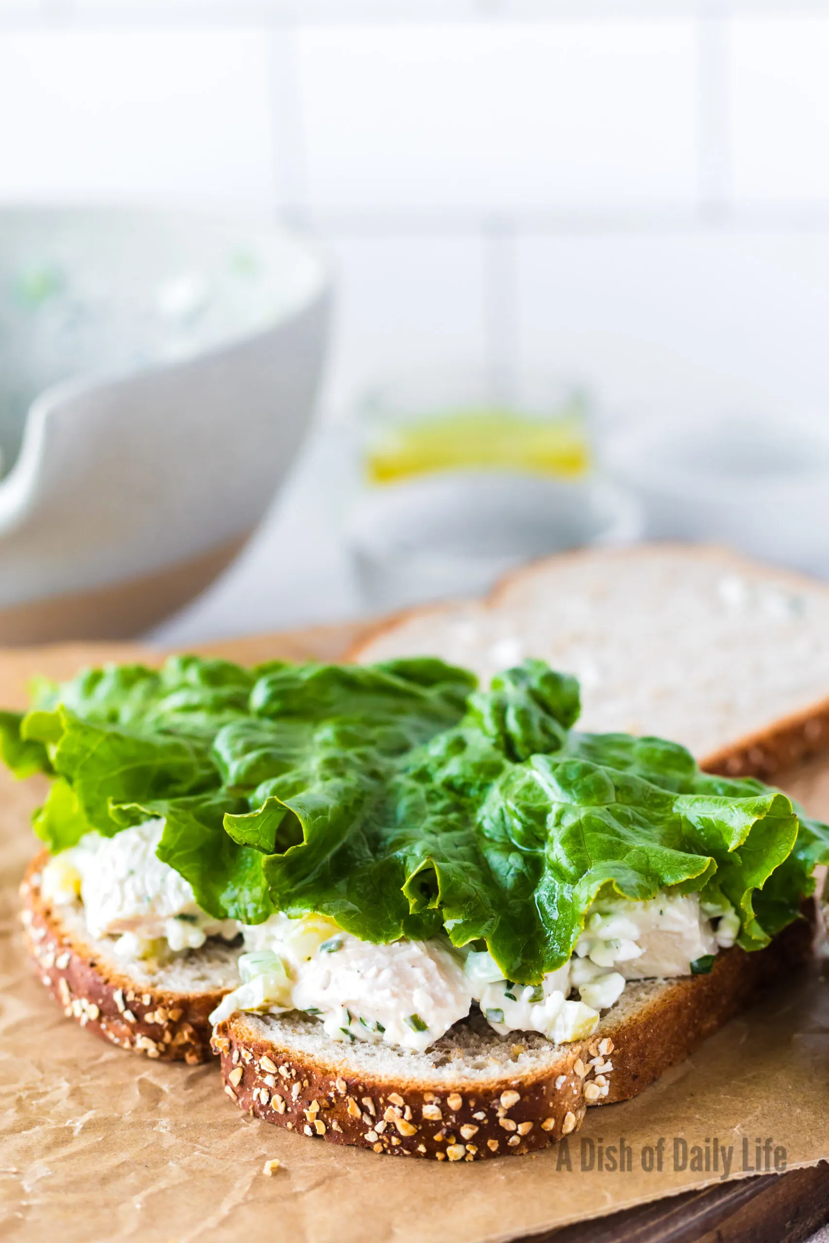 A piece of romain lettuce on top of chicken salad on bread