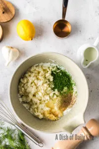 feta, garlic, fresh dill, lemon j uice, salt, black pepper, and milk added to feta and sour cream