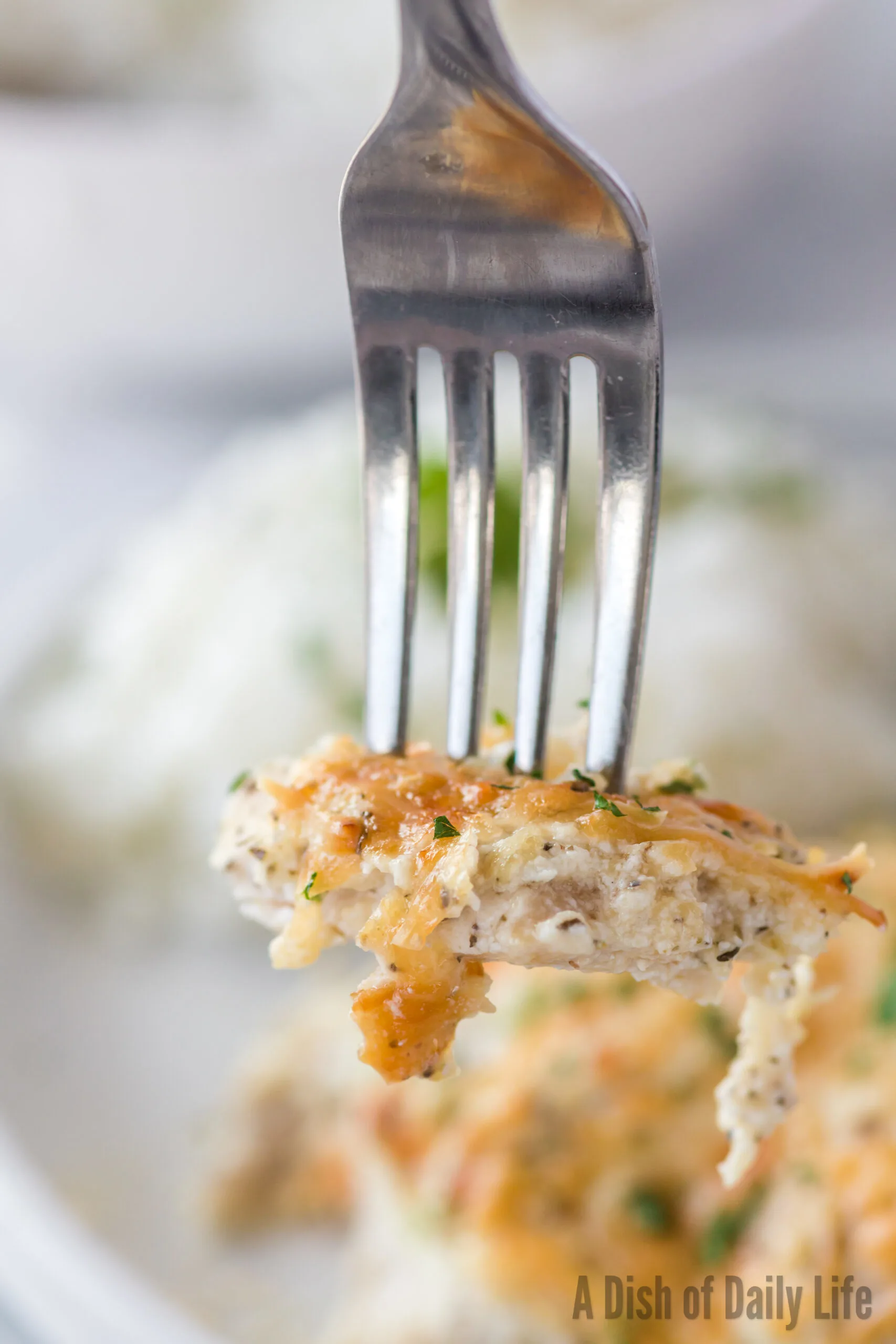 fork holding up a piece of sour cream chicken