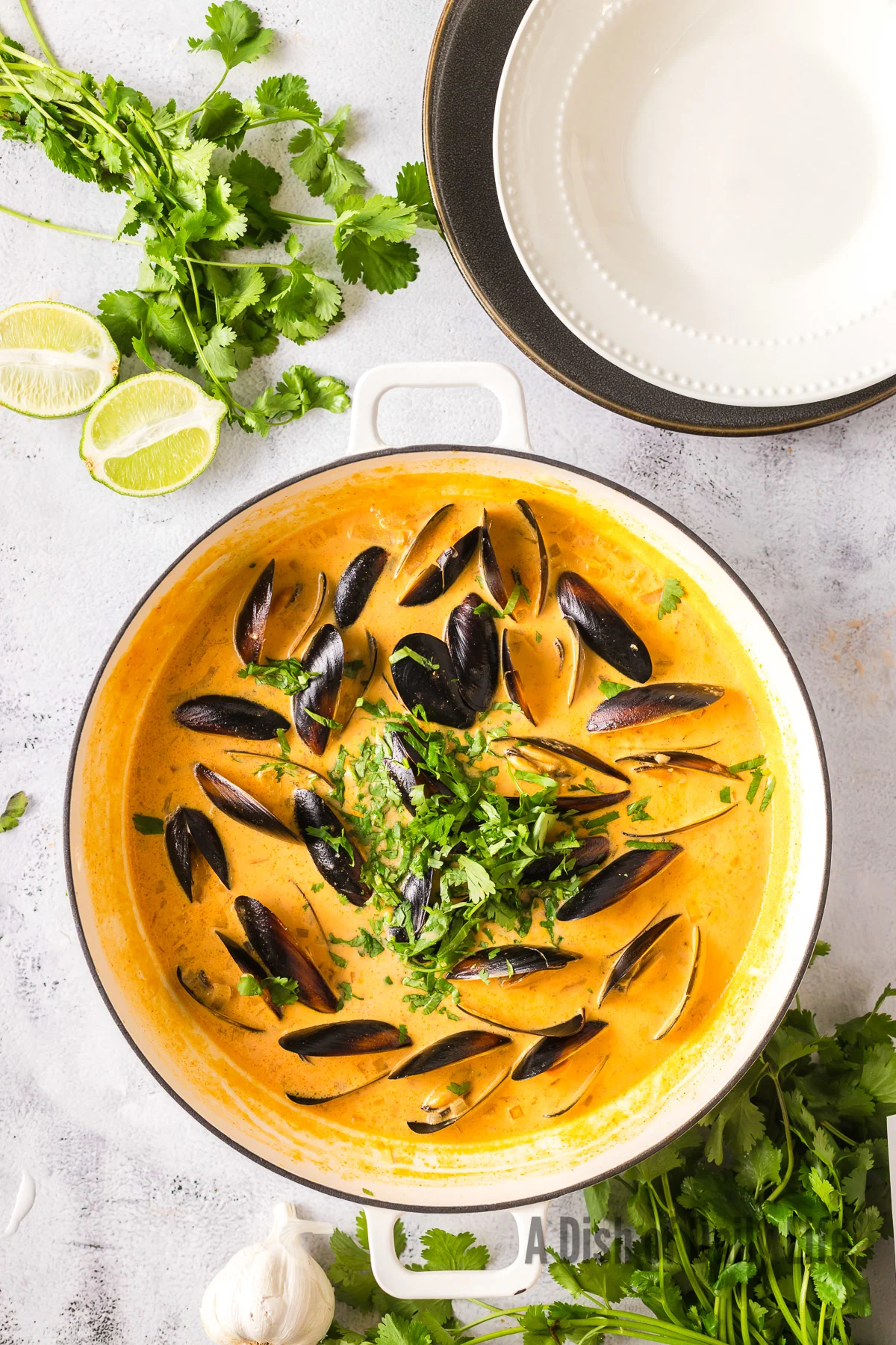 Cilantro and juice added to clam mix in pot.