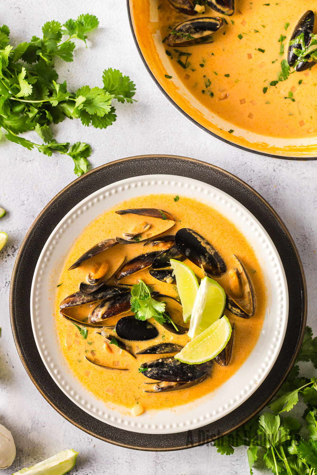 cooked clams in a red thai broth served in a bowl