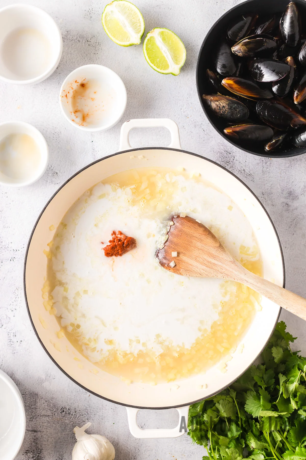 Clam juice, coconut milk, red curry paste and fish sauce added to skillet