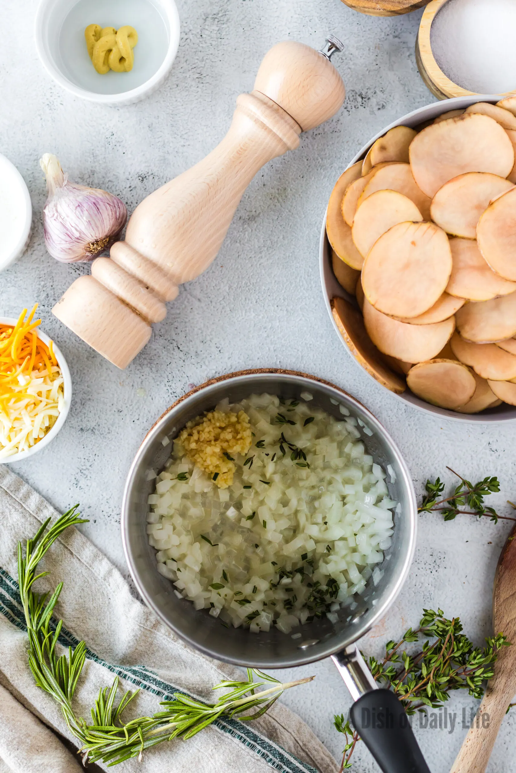 butter, onions, garlic, thyme, and rosemary all in a sauce pot.