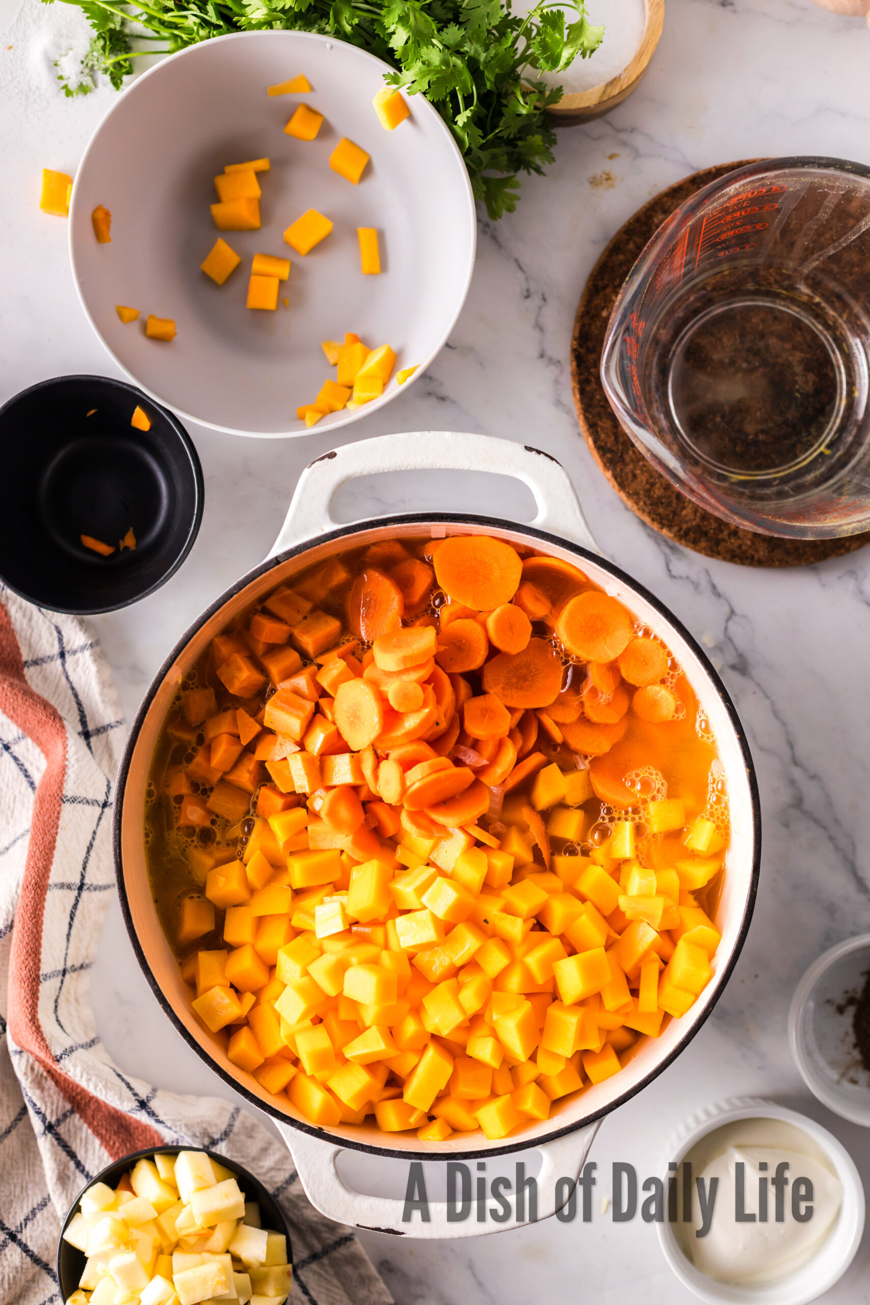 butternut squash, sweet potato and carrots added to onion mixture in soup pot.