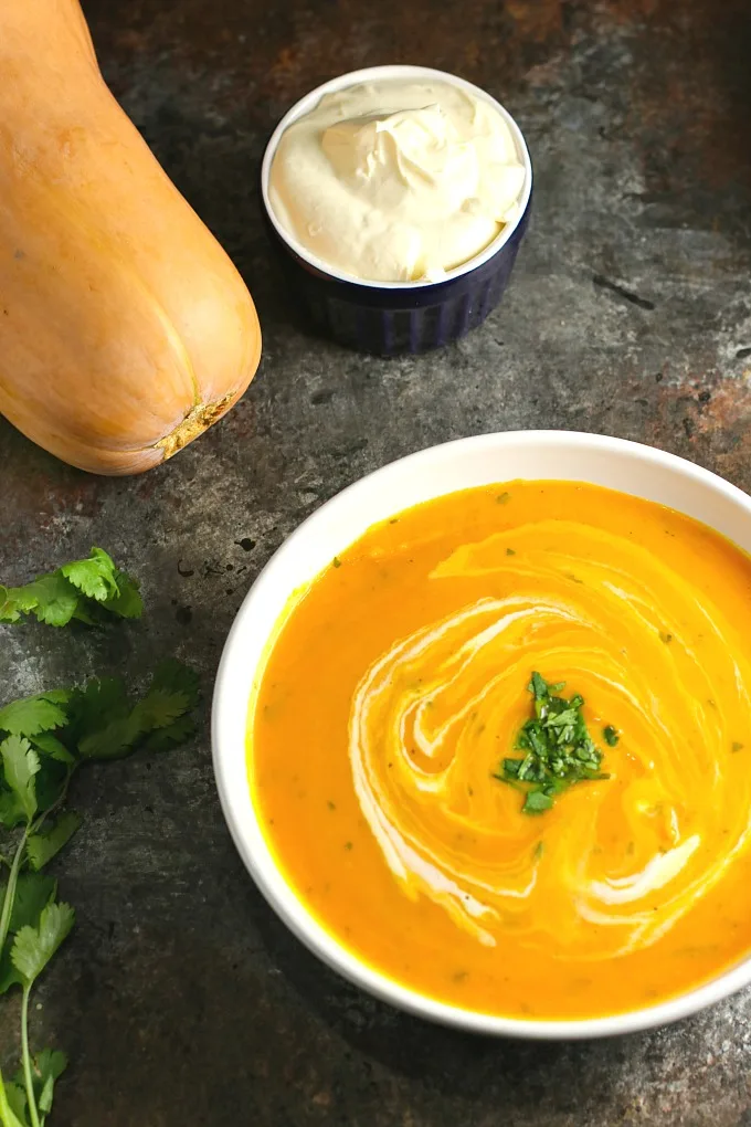 Gingered Butternut Squash Soup…a combination of butternut squash, sweet potato, carrots, and apples, accented by the delicate sweetness of ginger, and finished off with rich, creamy crème fraiche and cilantro. A delicious soup worthy of a special occasion! #butternutsquash #soup #holidayrecipes #Christmas #Thanksgiving 