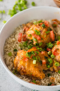 3 chicken thighs in a bowl of rice