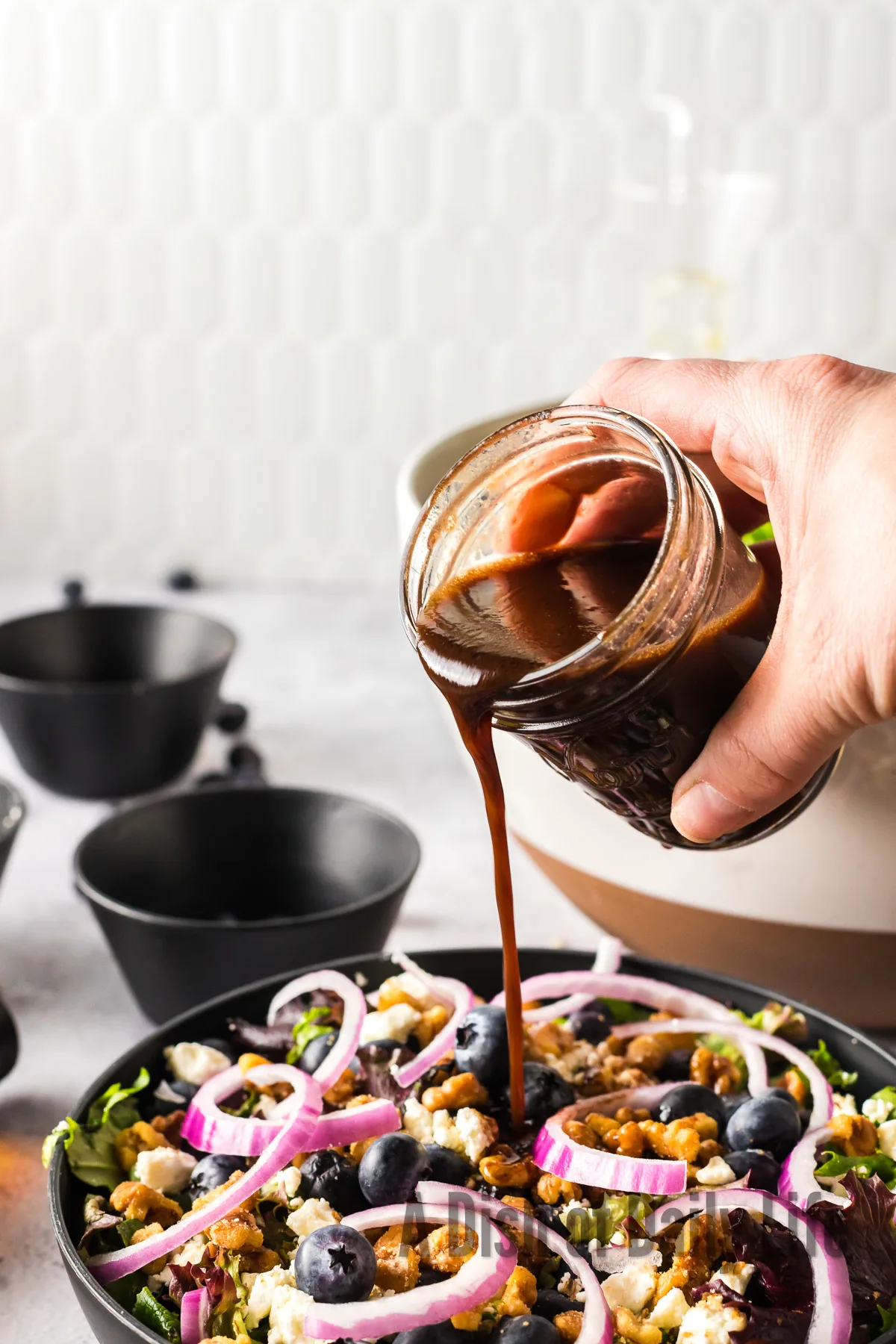 Balsamic Vinegar Salad Dressing being poured over the salad