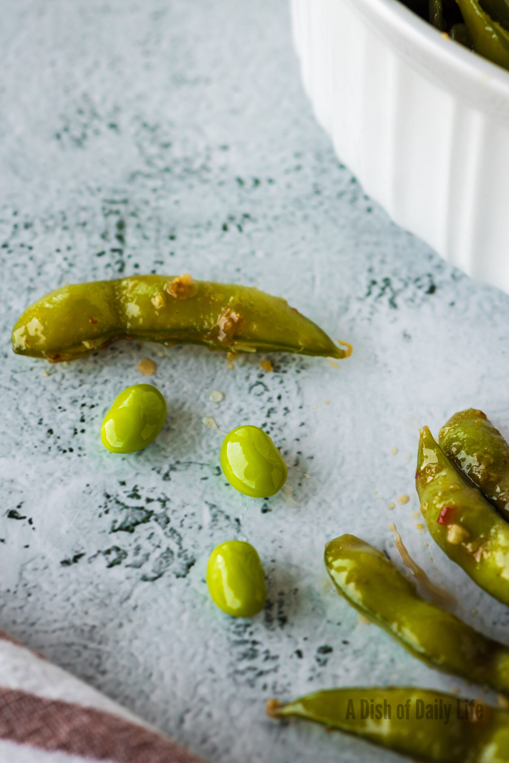 edamame laid out on counter with one opened up.