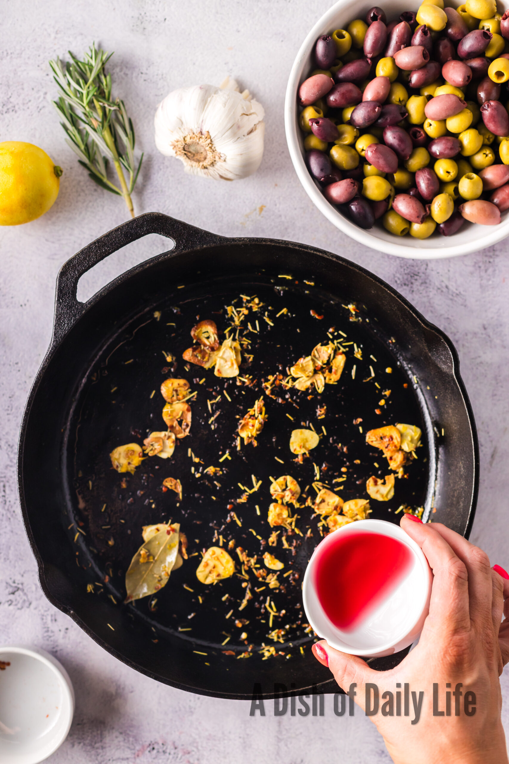 red wine vinegar added to garlic in skillet.