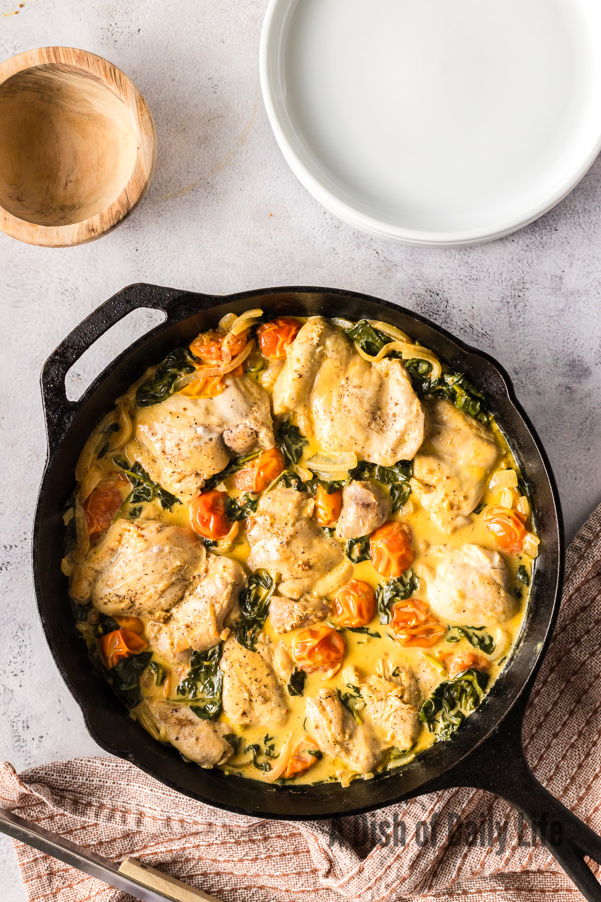 zoomed out image of chicken thighs in cream sauce cooked and ready to serve.