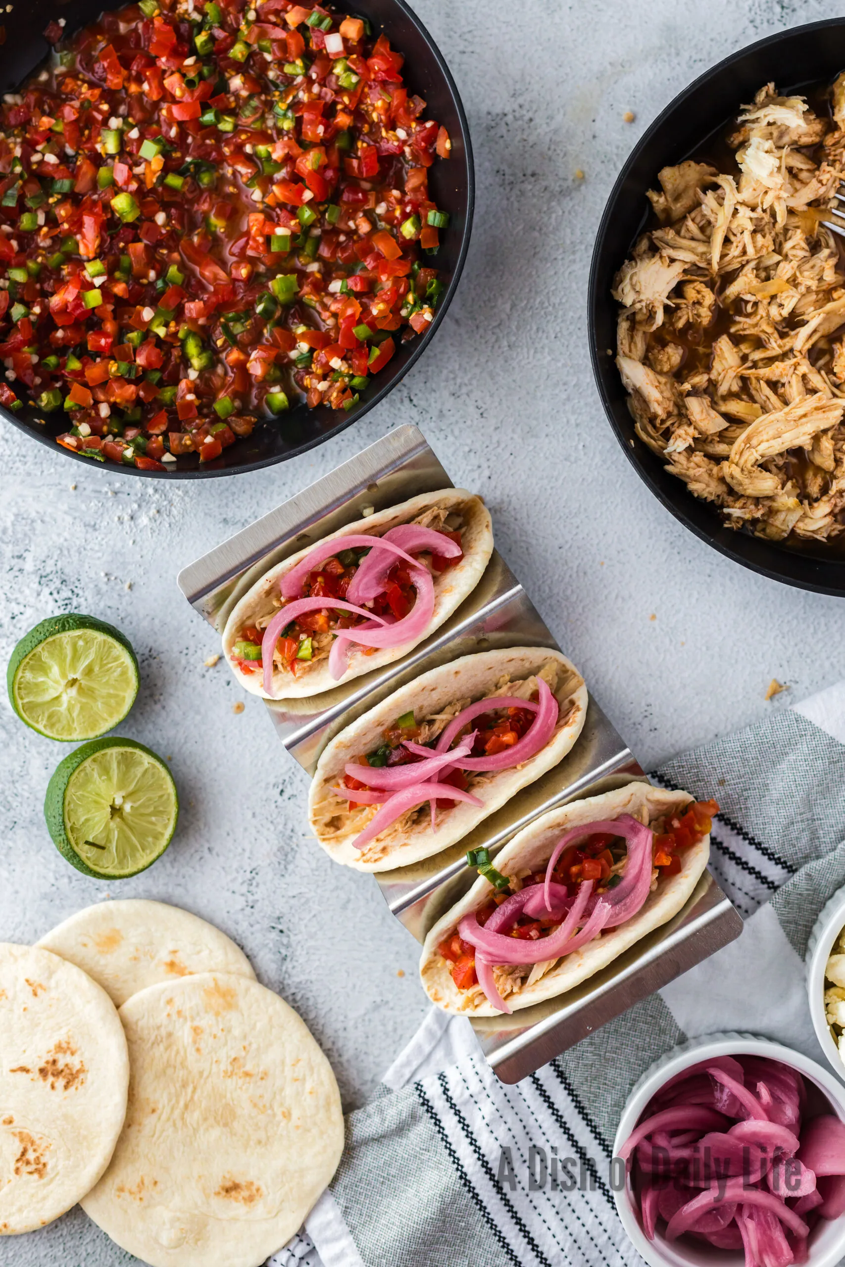 3 tacos with shredded chicken, salsa and pickled red onions