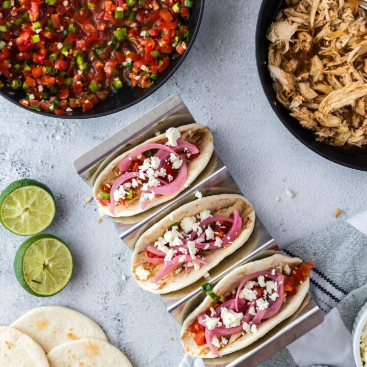 3 tacos with shredded chicken, salsa, pickled red onions and cheese