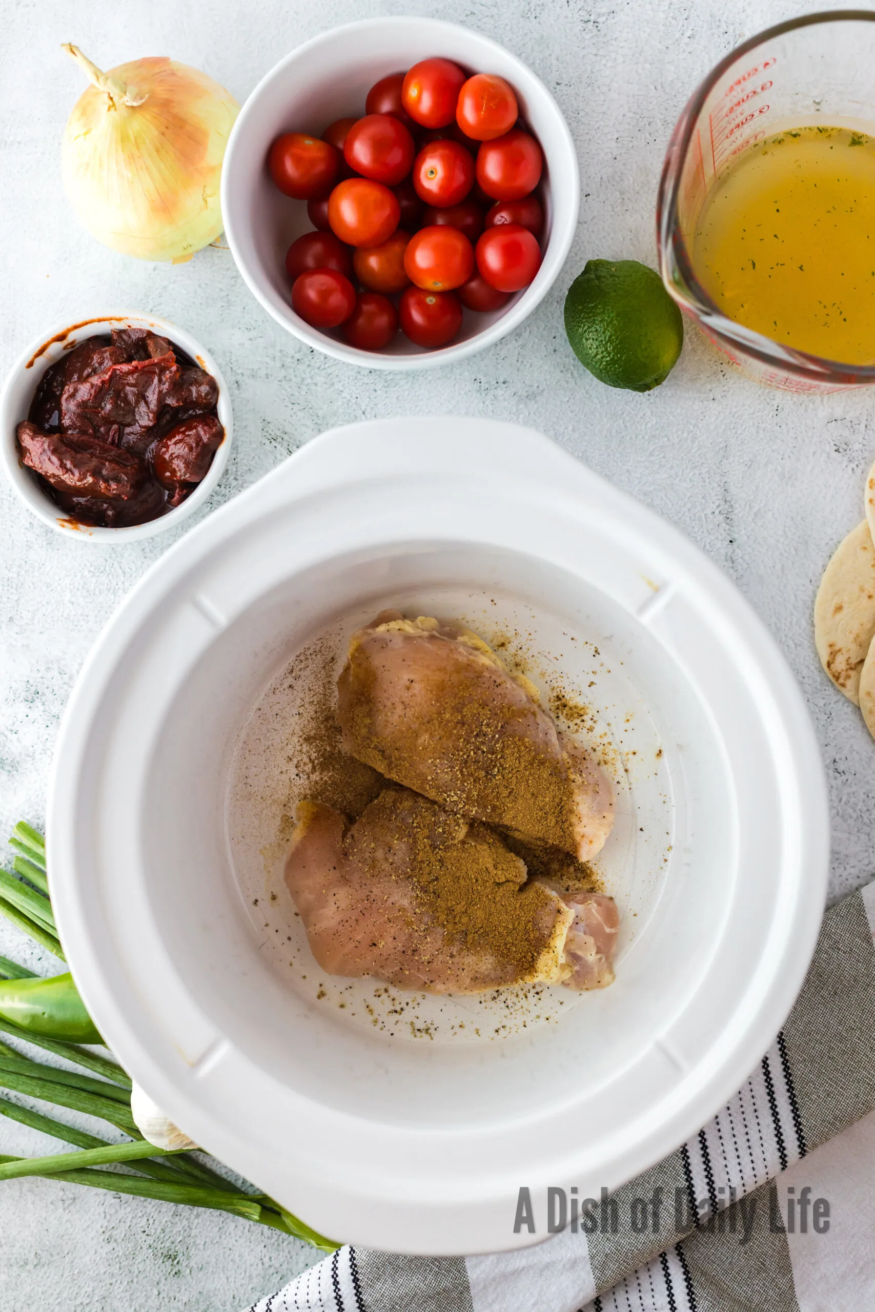 Raw chicken breasts with seasonings in crockpot