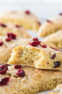 two scones stacked on top of each other. Top scone has a bite removed.